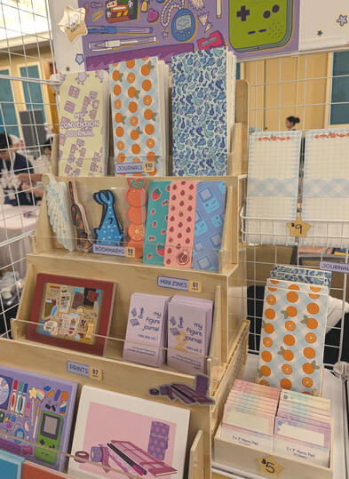 Table closeup Aug-Sept 2026 - journals, memo pads, journals, prints, zines